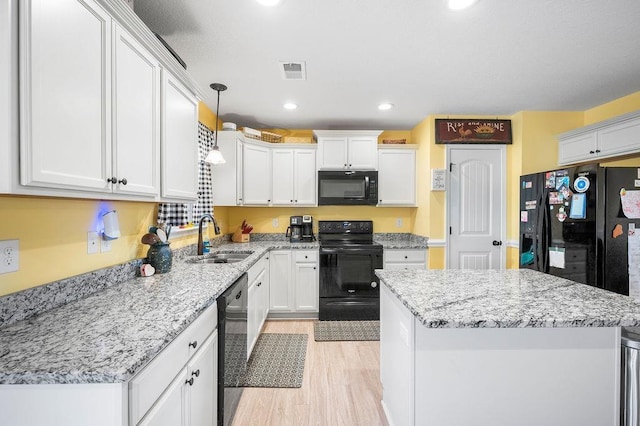 kitchen with sink, decorative light fixtures, white cabinetry, and black appliances