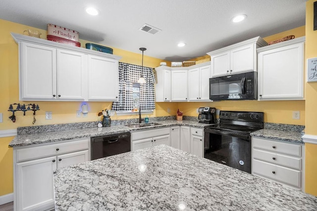 kitchen with pendant lighting, sink, white cabinets, and black appliances