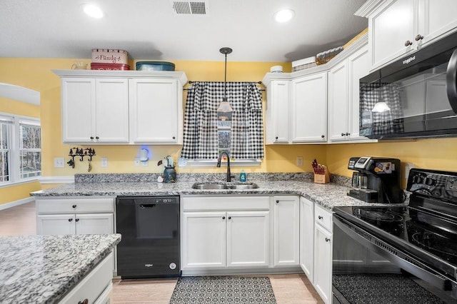 kitchen featuring black appliances, white cabinets, sink, hanging light fixtures, and light stone countertops