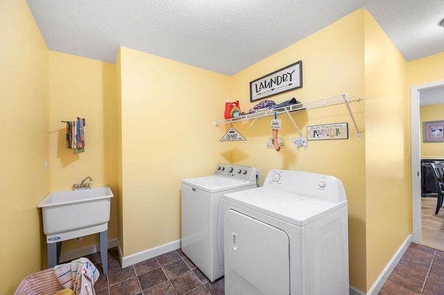 washroom featuring washing machine and dryer and a textured ceiling