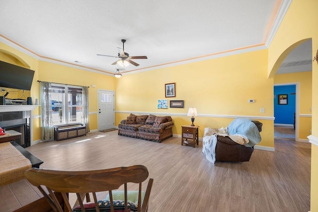 living room with ceiling fan, crown molding, and light hardwood / wood-style flooring