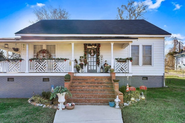 bungalow-style house featuring covered porch and a front yard