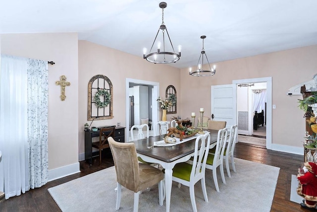 dining room with lofted ceiling, dark hardwood / wood-style flooring, and a notable chandelier