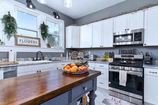 kitchen featuring white cabinets, butcher block counters, sink, and appliances with stainless steel finishes