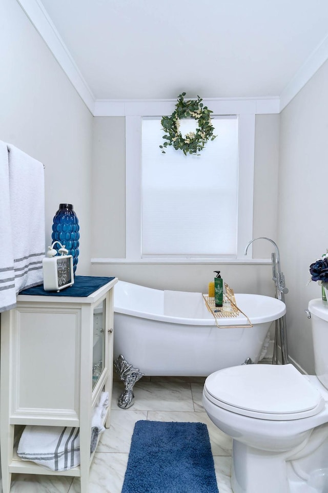 bathroom featuring crown molding, toilet, and a tub