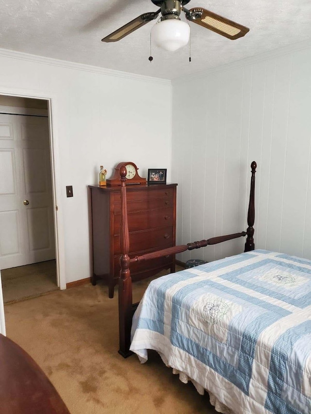 carpeted bedroom featuring ceiling fan, a closet, a textured ceiling, and ornamental molding