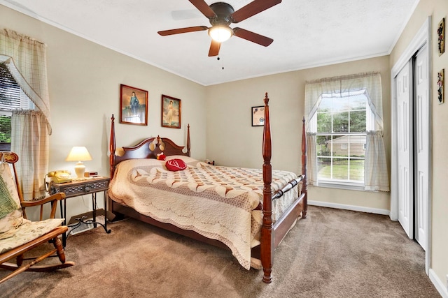 bedroom with ceiling fan, carpet floors, crown molding, and a closet