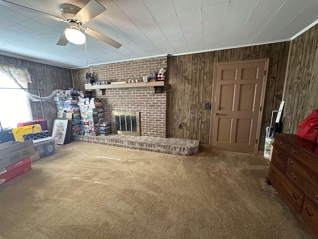 carpeted living room with a brick fireplace, ceiling fan, and wooden walls