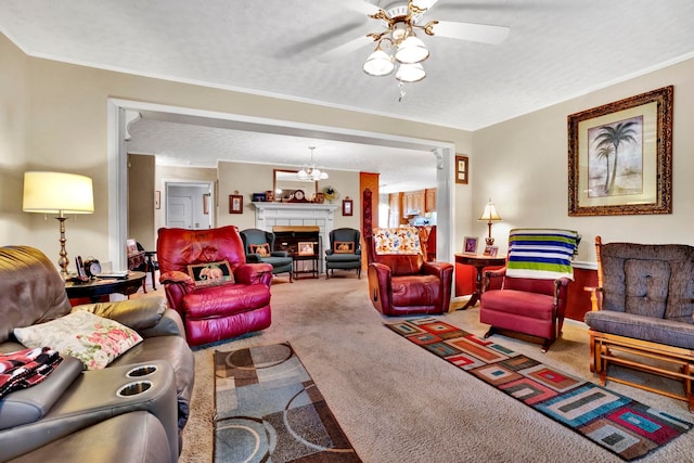 living room with ornamental molding, ceiling fan with notable chandelier, a textured ceiling, carpet floors, and a tiled fireplace