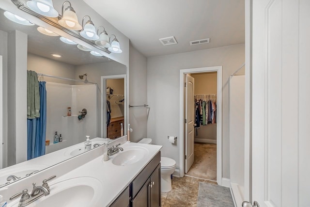 bathroom with a shower, vanity, and toilet