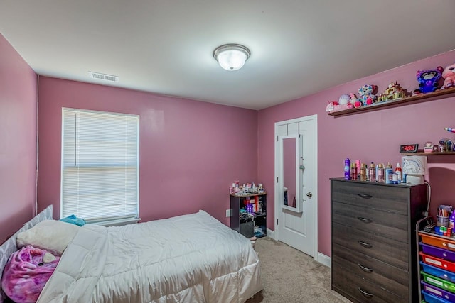 bedroom featuring light carpet and a closet