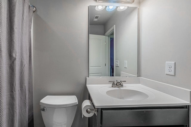 bathroom with vanity, curtained shower, and toilet