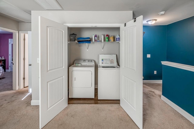 laundry room featuring separate washer and dryer and light carpet