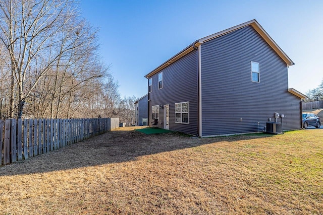 rear view of property with a lawn and central AC