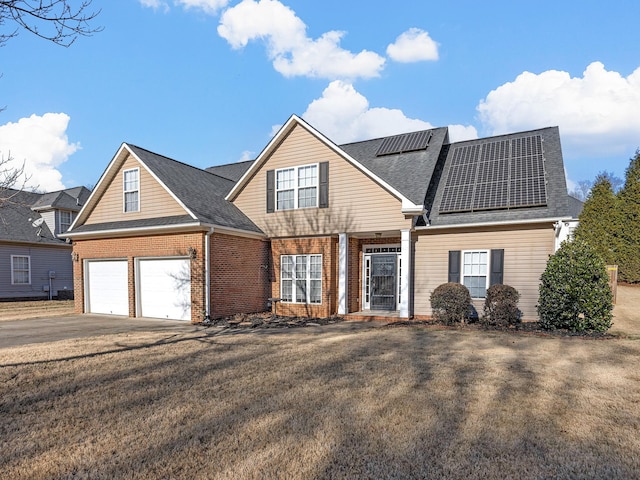 view of property featuring solar panels, a garage, and a front yard