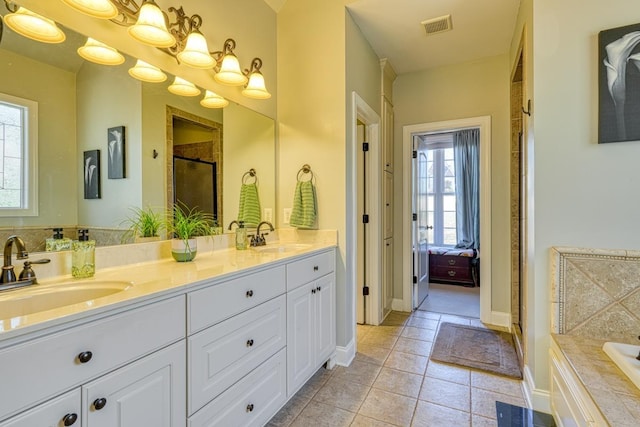 bathroom featuring tile patterned flooring, vanity, a healthy amount of sunlight, and independent shower and bath