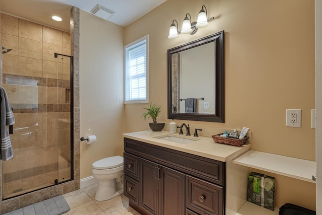 bathroom with toilet, vanity, tile patterned floors, and a shower with door