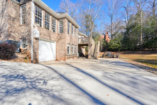 view of side of property featuring a garage and a wooden deck