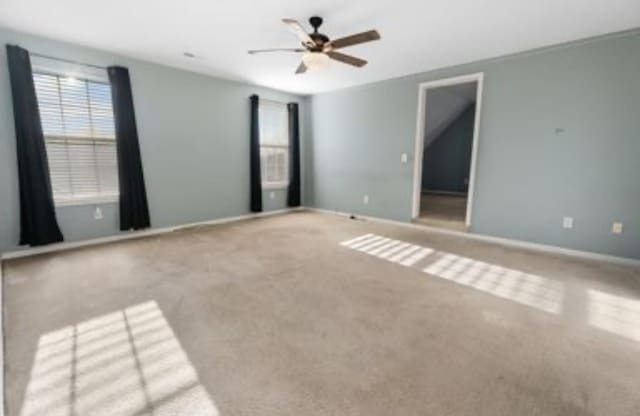 spare room featuring carpet flooring and ceiling fan