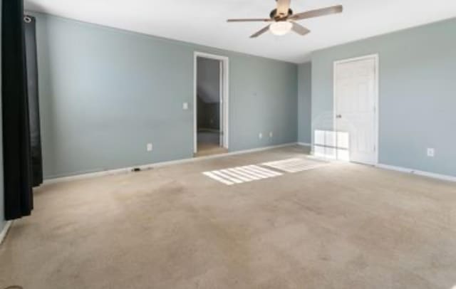 carpeted empty room featuring ceiling fan