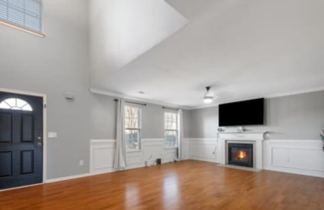 unfurnished living room featuring crown molding, hardwood / wood-style floors, and ceiling fan