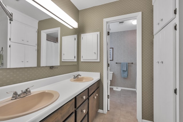 bathroom featuring tile patterned flooring, vanity, and toilet