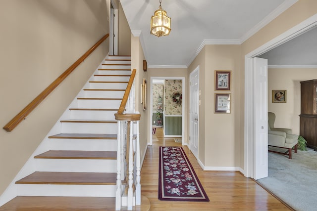 entrance foyer with a chandelier, light hardwood / wood-style floors, and ornamental molding