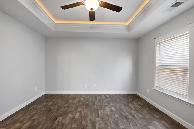 spare room with a tray ceiling, ceiling fan, and dark hardwood / wood-style floors