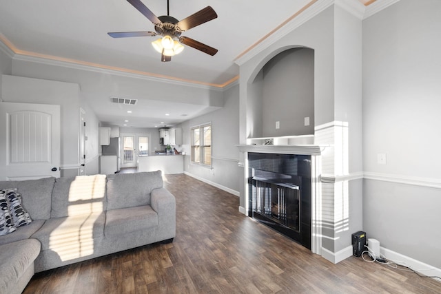 living room featuring dark hardwood / wood-style floors, ceiling fan, and ornamental molding