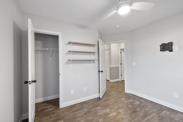 unfurnished bedroom with a closet, ceiling fan, and dark wood-type flooring