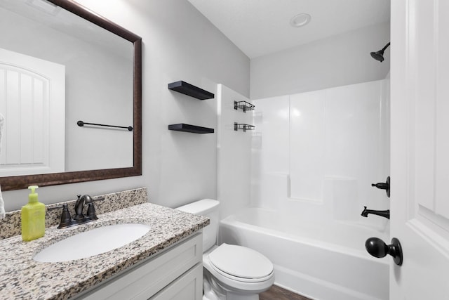 full bathroom featuring washtub / shower combination, vanity, and toilet