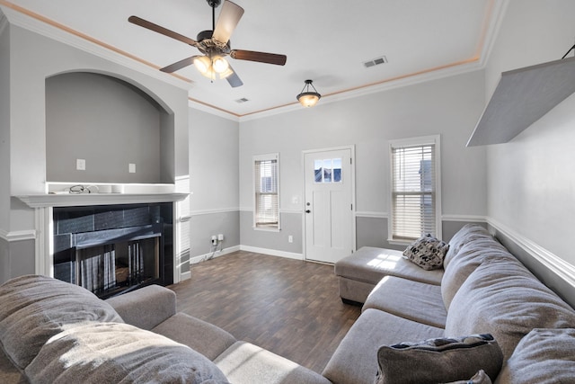 living room featuring a fireplace, dark hardwood / wood-style flooring, and crown molding