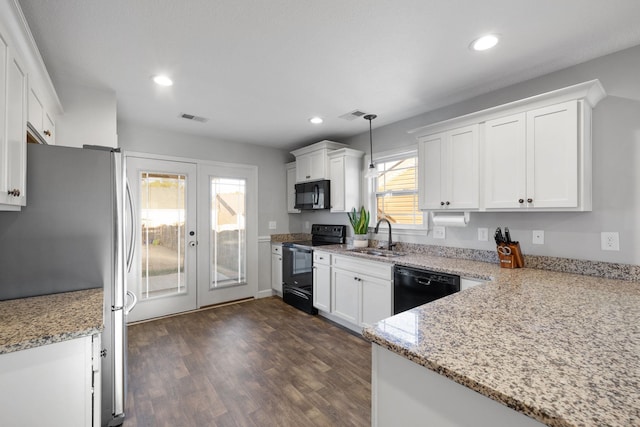 kitchen with sink, light stone counters, pendant lighting, white cabinets, and black appliances