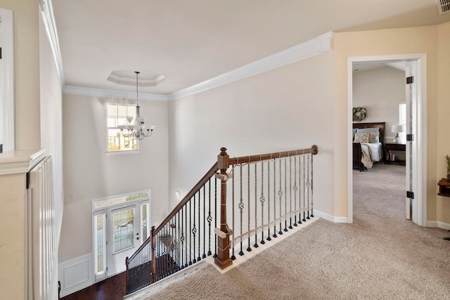 hall with carpet flooring, plenty of natural light, and a chandelier