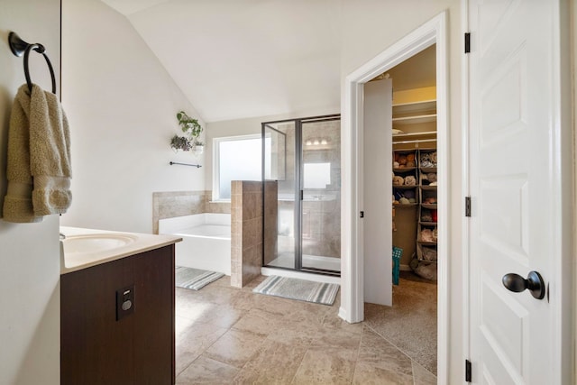 bathroom with vanity, independent shower and bath, and lofted ceiling