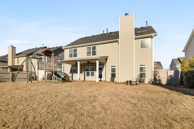 back of house featuring a lawn and ceiling fan