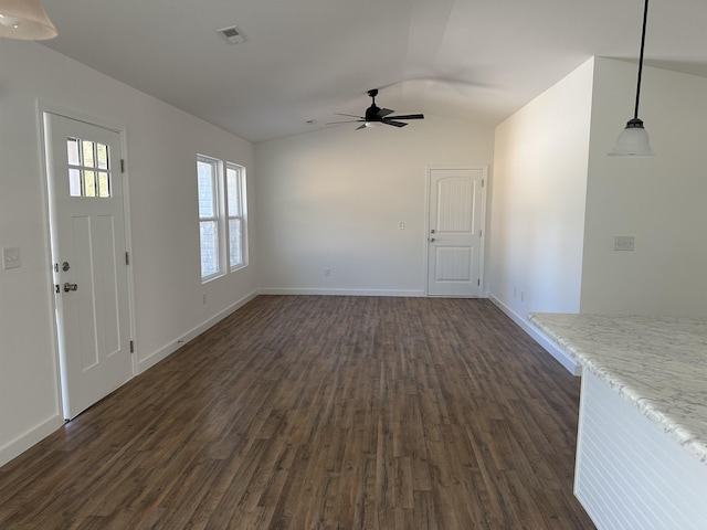 unfurnished living room featuring dark hardwood / wood-style floors, ceiling fan, and vaulted ceiling