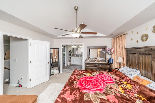 bedroom featuring ceiling fan, vaulted ceiling, ensuite bath, and light colored carpet