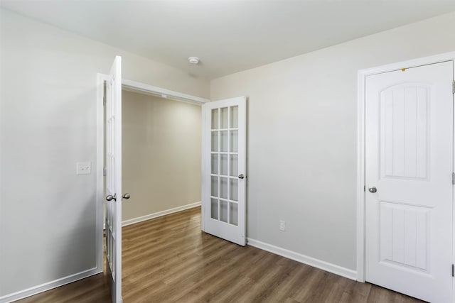 empty room with french doors and dark hardwood / wood-style flooring