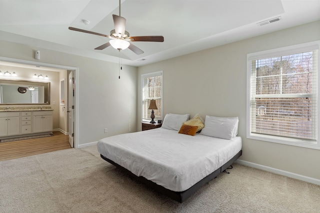 carpeted bedroom featuring vaulted ceiling, ceiling fan, and ensuite bath