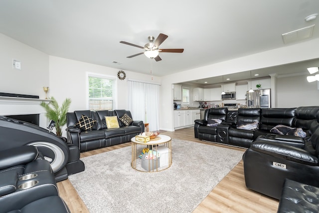 living room featuring ceiling fan and light wood-type flooring