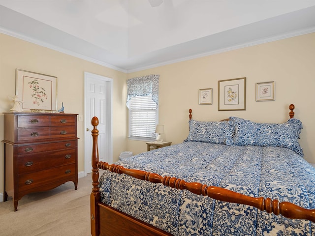 carpeted bedroom with a tray ceiling, ceiling fan, and ornamental molding