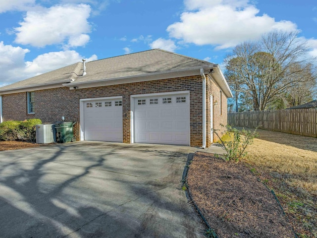 view of property exterior featuring central AC unit and a garage