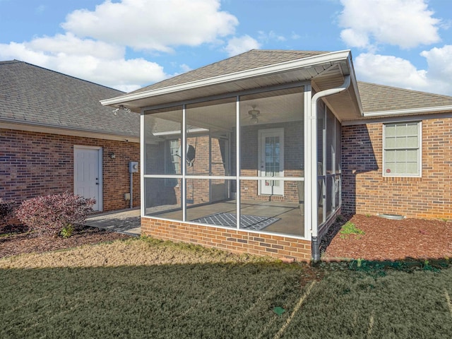 back of house featuring a lawn and a sunroom