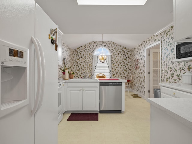 kitchen featuring hanging light fixtures, an inviting chandelier, stainless steel dishwasher, white refrigerator with ice dispenser, and white cabinets