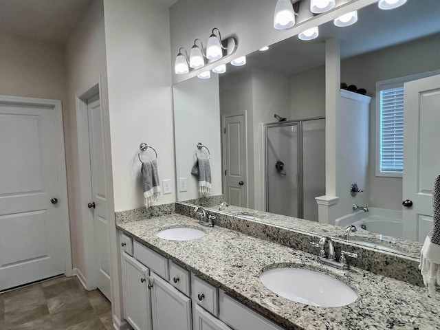 full bath featuring double vanity, a shower stall, and a sink