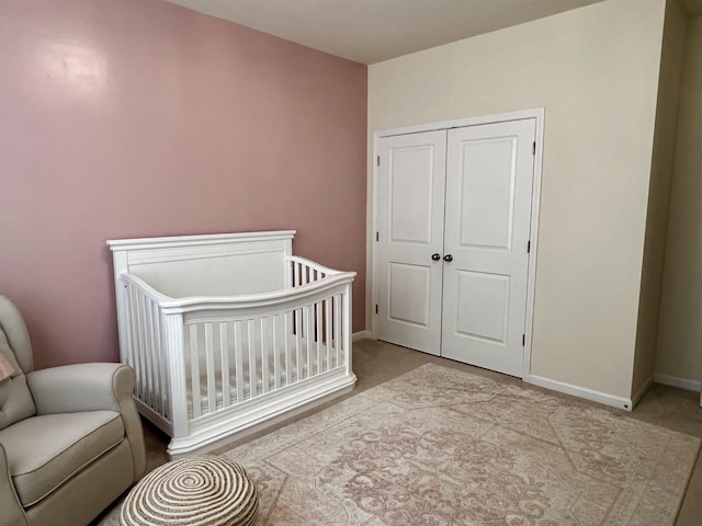 bedroom featuring a closet, a crib, and baseboards