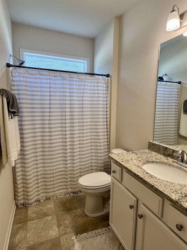 bathroom with curtained shower, vanity, and toilet