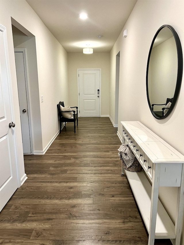 hall with dark wood-style floors and baseboards