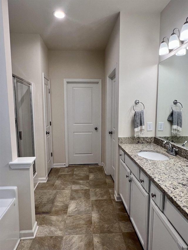 bathroom with a bath, a shower stall, vanity, and baseboards